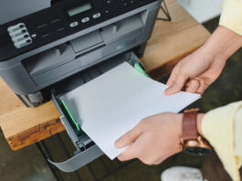 Man plaatst papier in printer