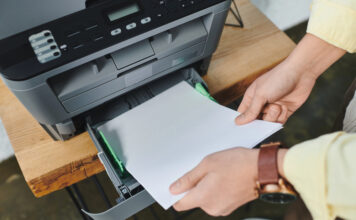 Toner printer of werken met cartridges? Maak de juiste keuze voor jouw bedrijf! Man plaatst papier in printer