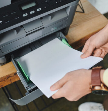 Toner printer of werken met cartridges? Maak de juiste keuze voor jouw bedrijf! Man plaatst papier in printer